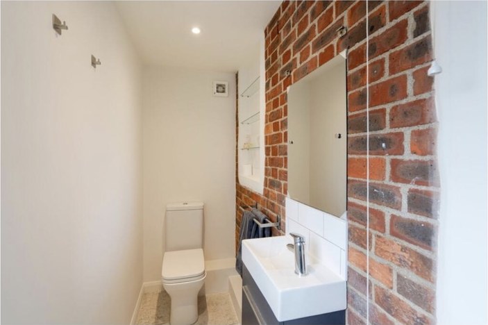 Shower room built against an exposed brick wall