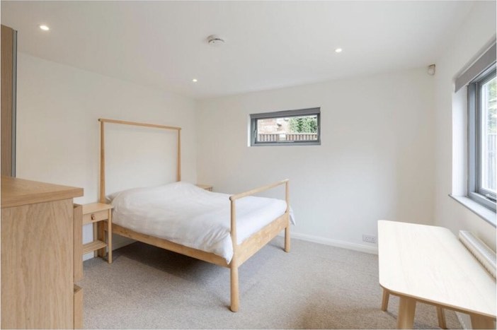 A double bedroom with a desk under the window