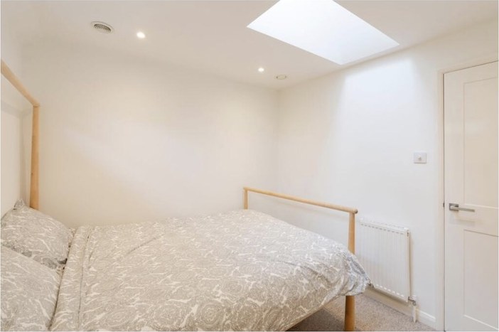 A double bedroom lit by a skylight