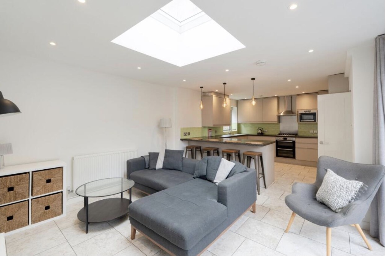 Open-plan living area with corner sofa under a rooflight